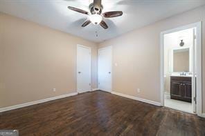 unfurnished bedroom featuring hardwood / wood-style flooring, ceiling fan, and connected bathroom