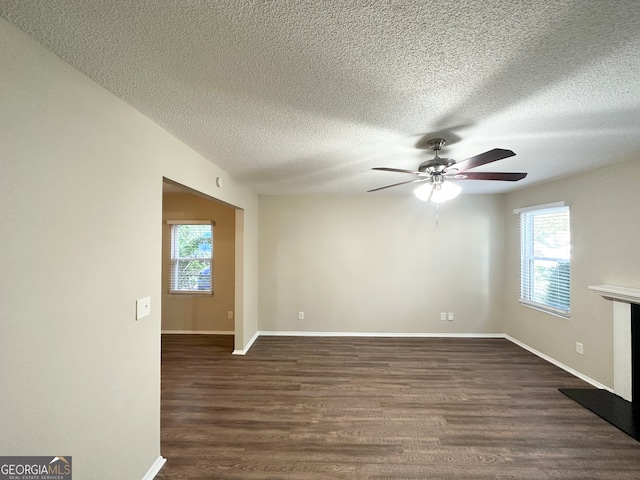 spare room with dark hardwood / wood-style floors, ceiling fan, and a textured ceiling