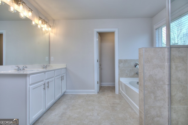 1091 Boulder Dr, Gray, GA 31032 - bathroom with tile patterned floors, a bath, double vanity, and baseboards