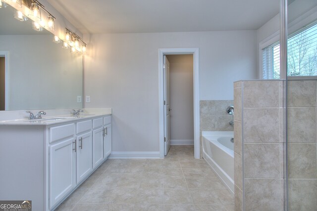 1091 Boulder Dr, Gray, GA 31032 - bathroom with tile patterned floors, a garden tub, double vanity, and baseboards
