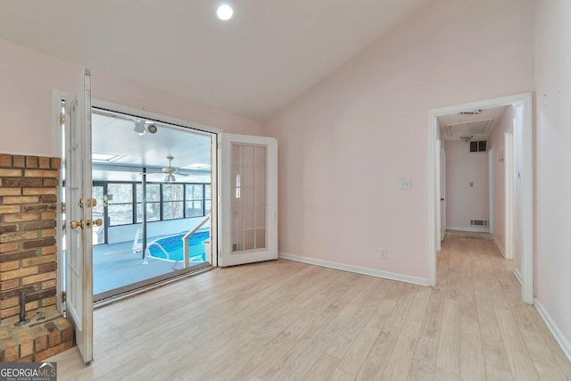 empty room with lofted ceiling and light hardwood / wood-style flooring