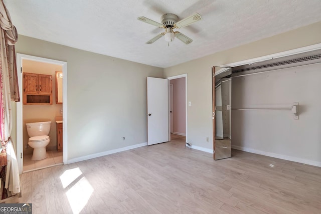 unfurnished bedroom with ensuite bath, ceiling fan, light hardwood / wood-style floors, a textured ceiling, and a closet