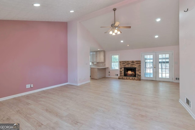 unfurnished living room with french doors, ceiling fan, high vaulted ceiling, and light hardwood / wood-style flooring