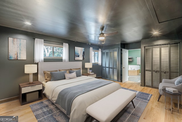 bedroom featuring ceiling fan, light wood-type flooring, and connected bathroom