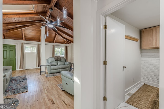 living room with vaulted ceiling with beams, ceiling fan, wooden ceiling, and light hardwood / wood-style floors