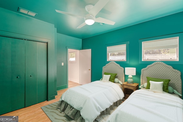 bedroom featuring ceiling fan, a closet, and light hardwood / wood-style floors