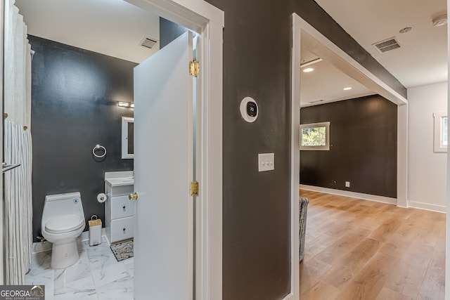 bathroom with vanity, wood-type flooring, and toilet