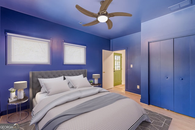 bedroom with light hardwood / wood-style floors, a closet, and ceiling fan