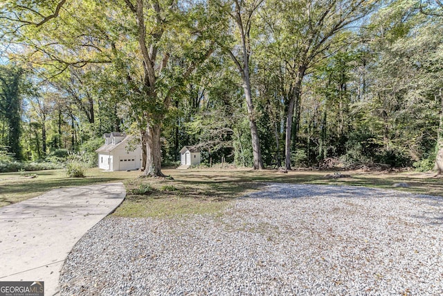 view of yard featuring a garage and a storage shed