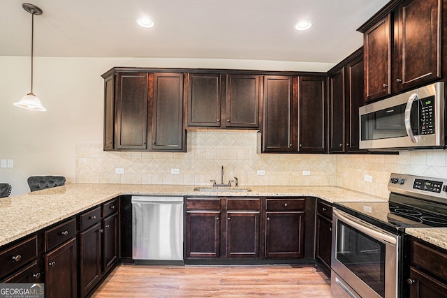 kitchen with sink, hanging light fixtures, dark brown cabinets, light hardwood / wood-style floors, and stainless steel appliances