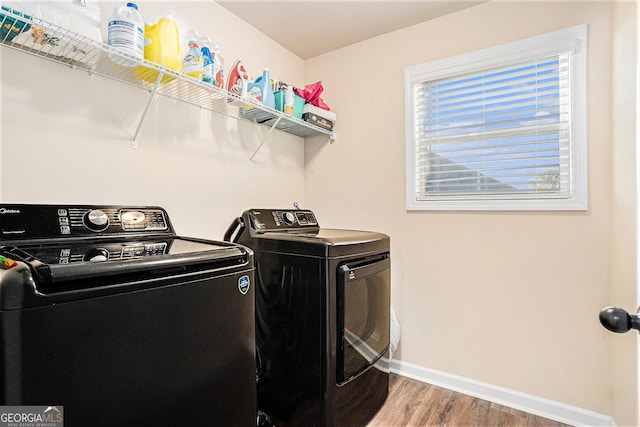 laundry room with hardwood / wood-style flooring and washing machine and clothes dryer