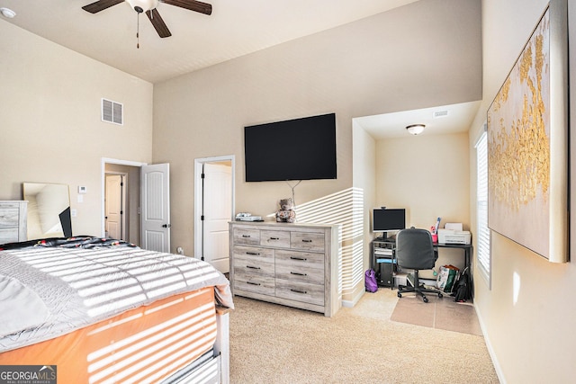 bedroom with light carpet, a high ceiling, and ceiling fan