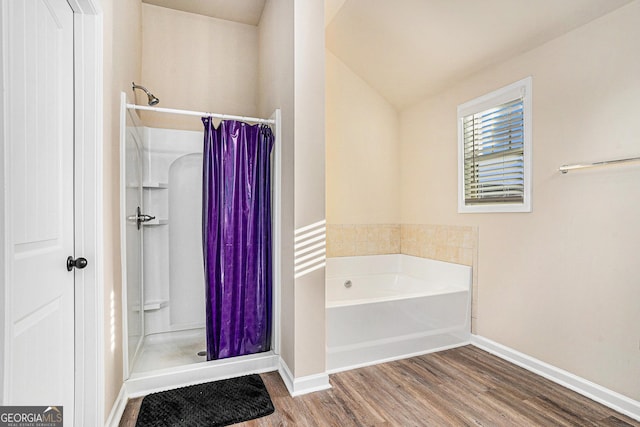 bathroom featuring hardwood / wood-style floors, vaulted ceiling, and shower with separate bathtub