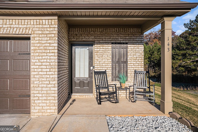 view of patio / terrace with a porch and a garage