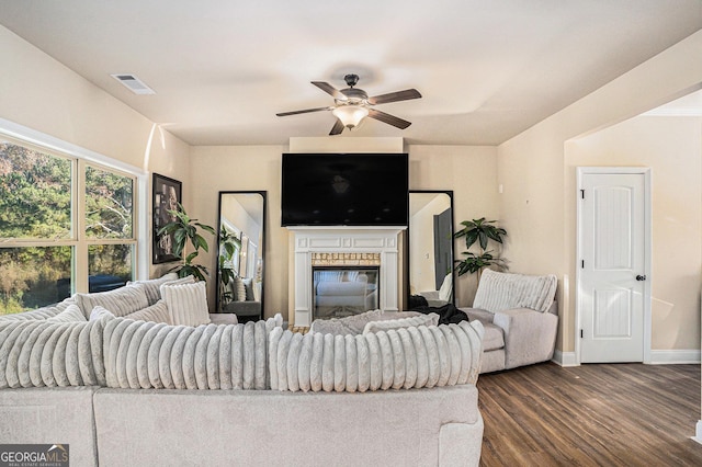 living room featuring ceiling fan and dark wood-type flooring