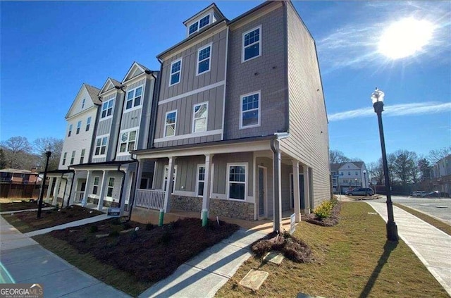 multi unit property with board and batten siding, stone siding, and covered porch