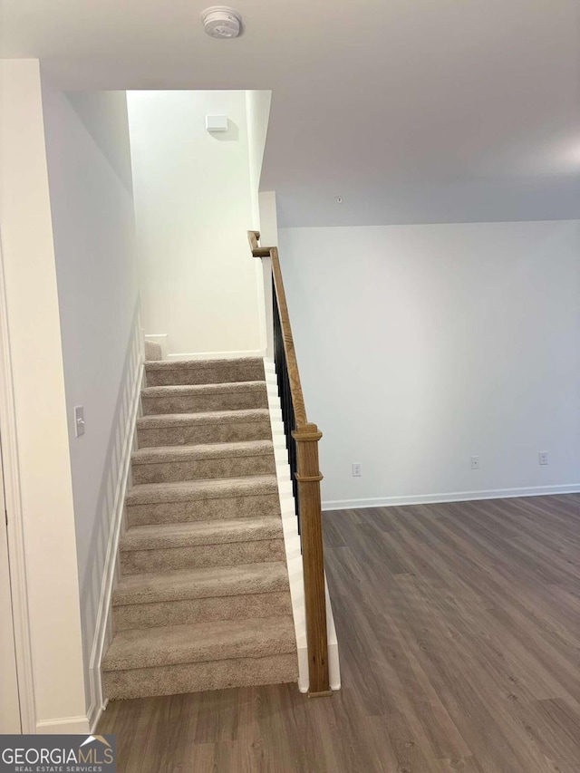 staircase with hardwood / wood-style floors and sink