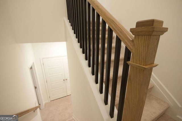 stairs featuring baseboards and carpet