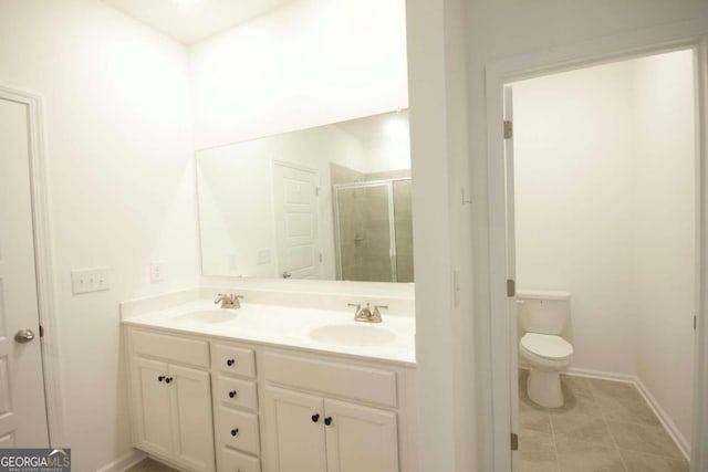 full bath with baseboards, a sink, double vanity, and a stall shower