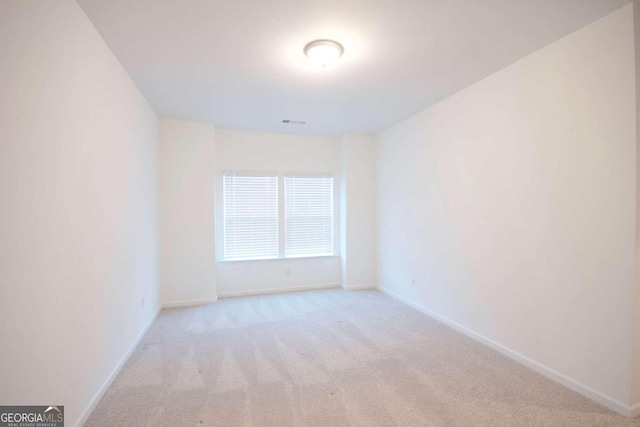 spare room featuring light colored carpet