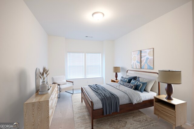 bedroom with visible vents, baseboards, and light colored carpet