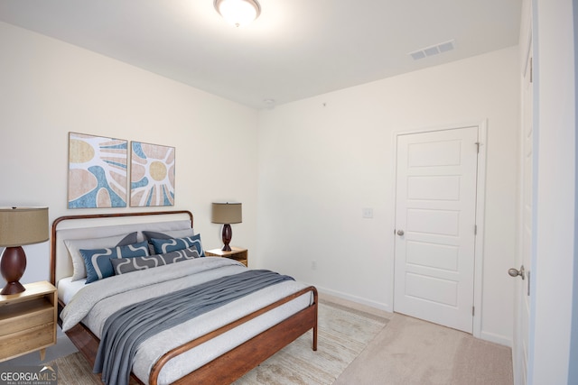 bedroom with light carpet, visible vents, and baseboards