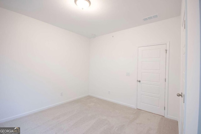 unfurnished room with light carpet, visible vents, and baseboards