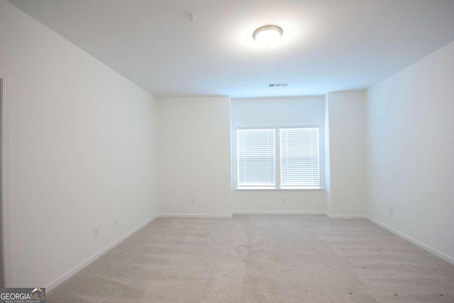 unfurnished room featuring visible vents, baseboards, and light carpet