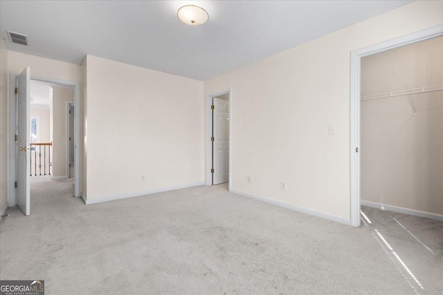 unfurnished bedroom with light carpet and a closet