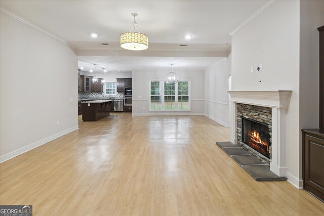 unfurnished living room featuring a fireplace, light hardwood / wood-style flooring, and ornamental molding