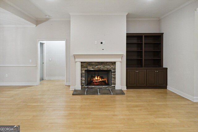 unfurnished living room featuring a fireplace, light wood-type flooring, and ornamental molding