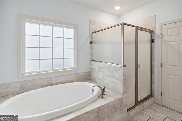 bathroom with separate shower and tub, a wealth of natural light, and tile patterned floors