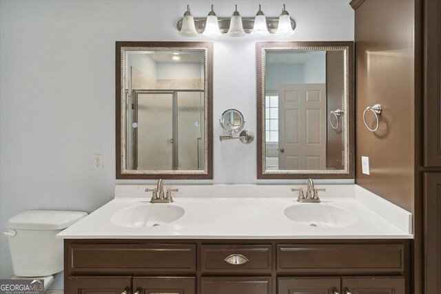 bathroom with vanity, toilet, and a shower with shower door