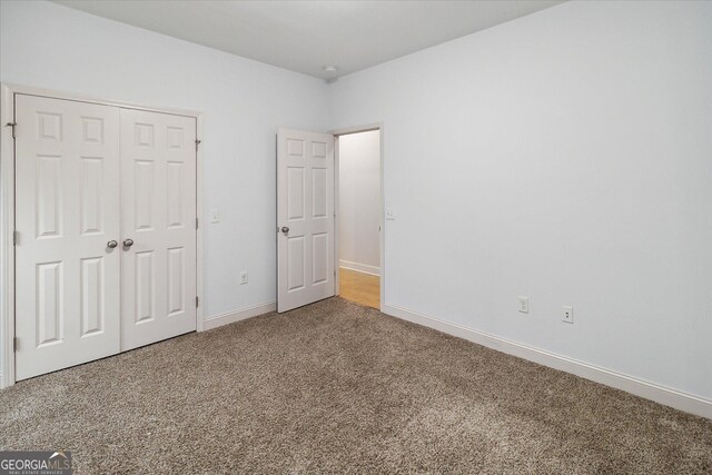 unfurnished bedroom featuring carpet and a closet