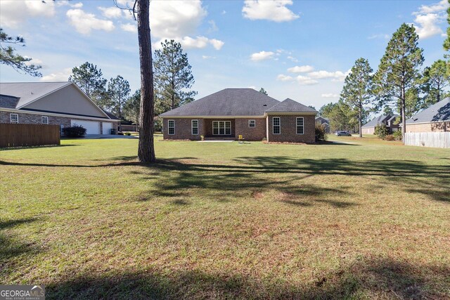 rear view of property featuring a lawn