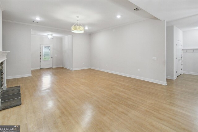 unfurnished living room featuring a fireplace, light hardwood / wood-style floors, and ornamental molding