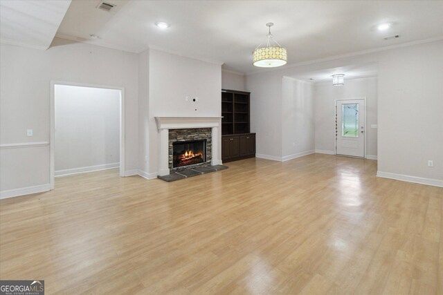 unfurnished living room with a fireplace, light hardwood / wood-style floors, and ornamental molding