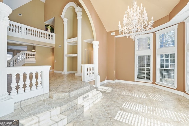 tiled dining space with a notable chandelier, built in shelves, high vaulted ceiling, and decorative columns