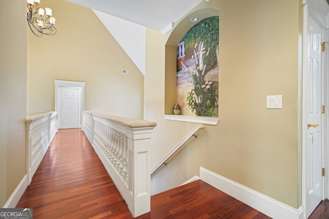 corridor featuring dark hardwood / wood-style flooring and an inviting chandelier