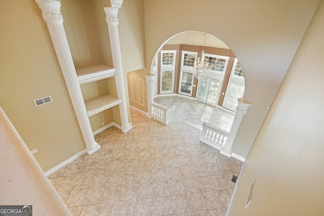 corridor featuring light tile patterned floors and a notable chandelier