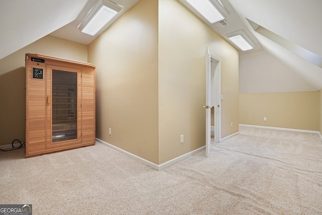 bonus room with light colored carpet and lofted ceiling