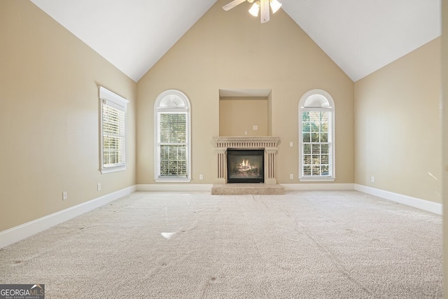 unfurnished living room with ceiling fan, light colored carpet, and high vaulted ceiling