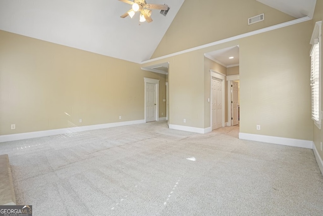 carpeted spare room featuring ceiling fan, high vaulted ceiling, and ornamental molding