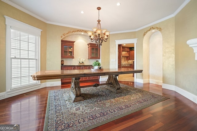 dining space with dark hardwood / wood-style floors, an inviting chandelier, and ornamental molding