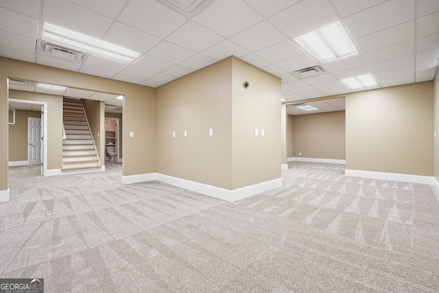 basement with light carpet and a drop ceiling