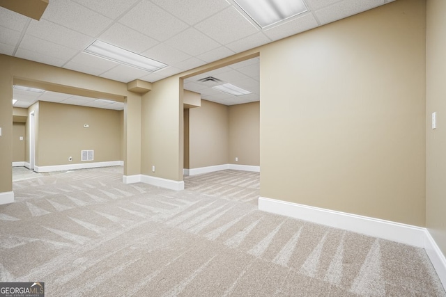 basement featuring carpet flooring and a paneled ceiling