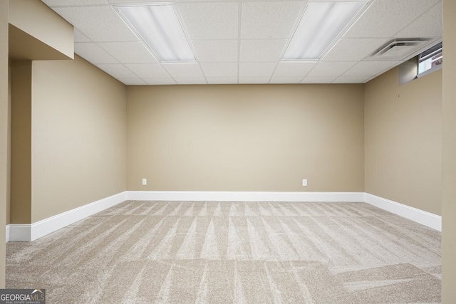 empty room featuring carpet flooring and a drop ceiling