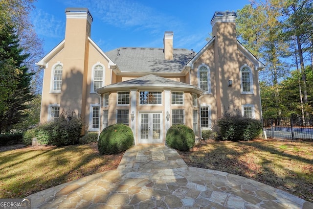 view of front facade with a front yard and french doors