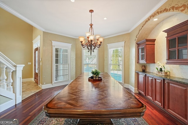 dining room featuring a chandelier, crown molding, and dark wood-type flooring