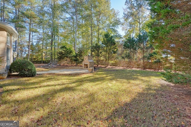 view of yard featuring an outdoor fireplace